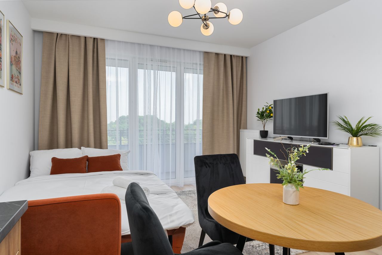 services-01 A bright modern studio apartment features a cozy living area with elegant decor.
