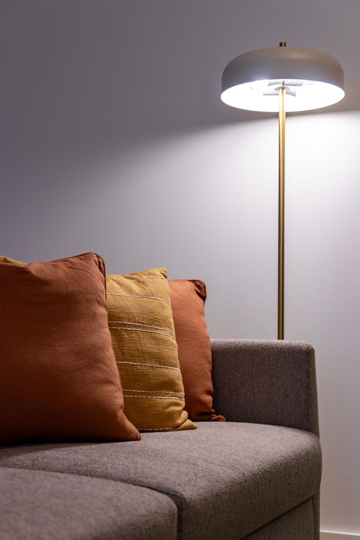 Elegant living room scene featuring a modern lamp and a comfortable sofa with cushions in Portugal.
